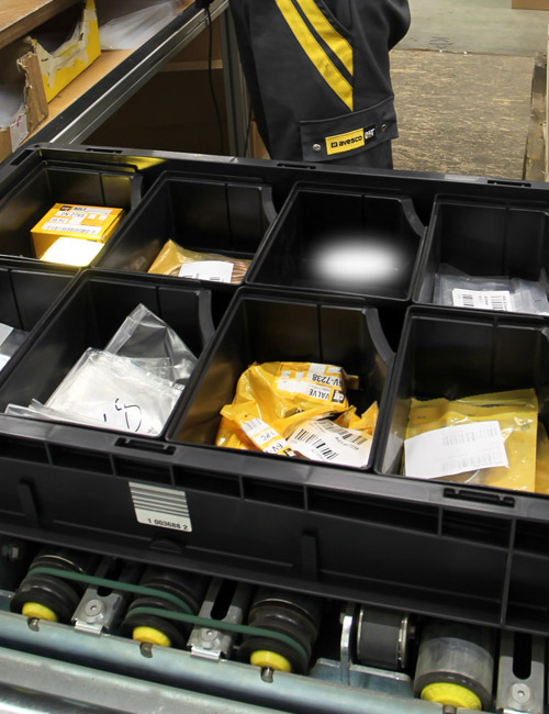 Ein einzelnes Fach in einem unterteilten Behälter wird mit Tray ausgeleuchtet, um den richtige Artikel zu picken.